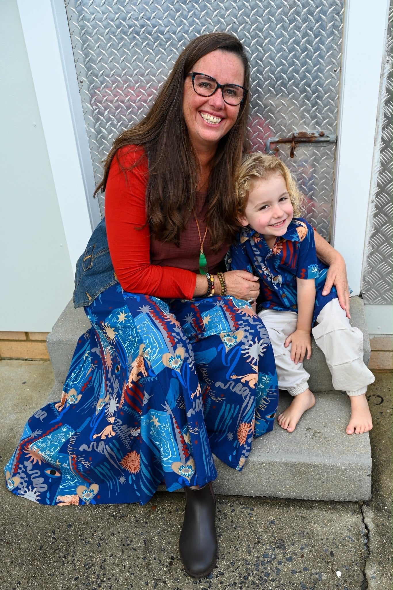 A woman and a young child sitting together while wearing a Tallows Shirt Wanderlust Navy and Wanderlust Navy Pants.