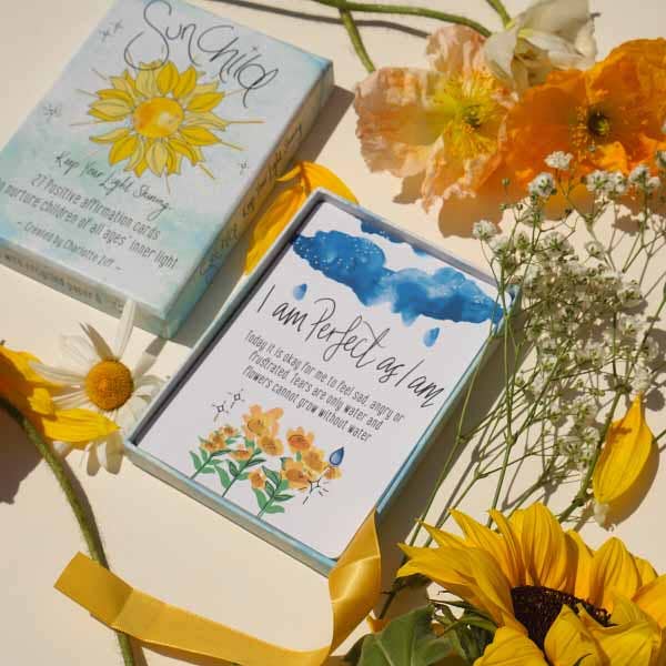 Card with 'I am perfect as I am' message surrounded by sunflowers and other flowers