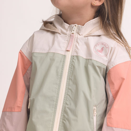 Color-blocked kids' waterproof jacket featuring an off-white upper body and hood, a sage green central torso, and terracotta pink sleeves with a cream zipper.