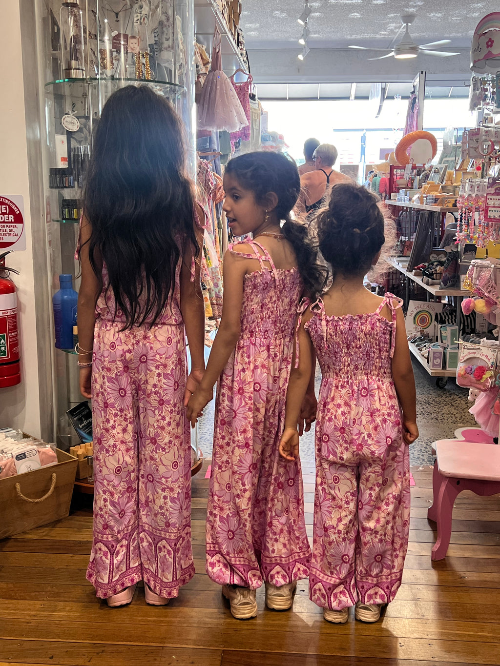Three young girls wearing Lilac haze print, bohemian-style in vibrant shades of magenta, pink, and cream.