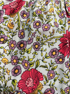 A close-up of a Aqua Wildflower print, a aqua blue floral fabric print featuring large red flowers, purple daisies, and green leaves.